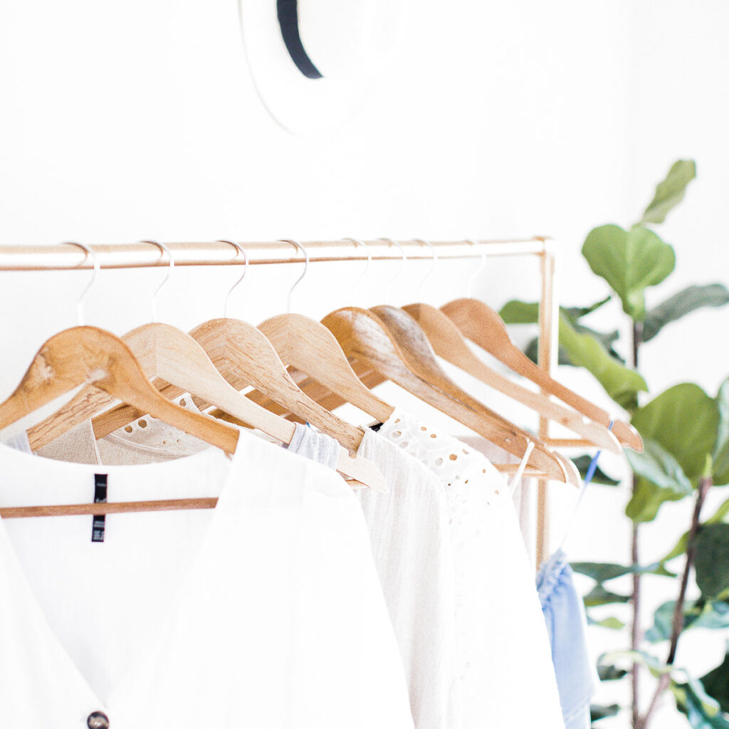 A white wardrobe on a metal clothes rail, as a way to signify a life makeover