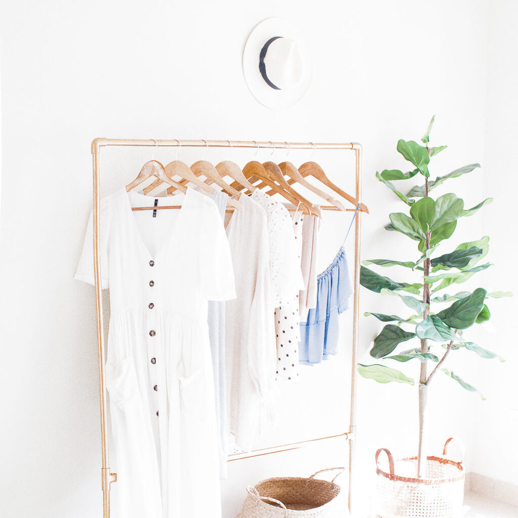 A white wardrobe on a metal clothes rail, as a way to signify a life makeover